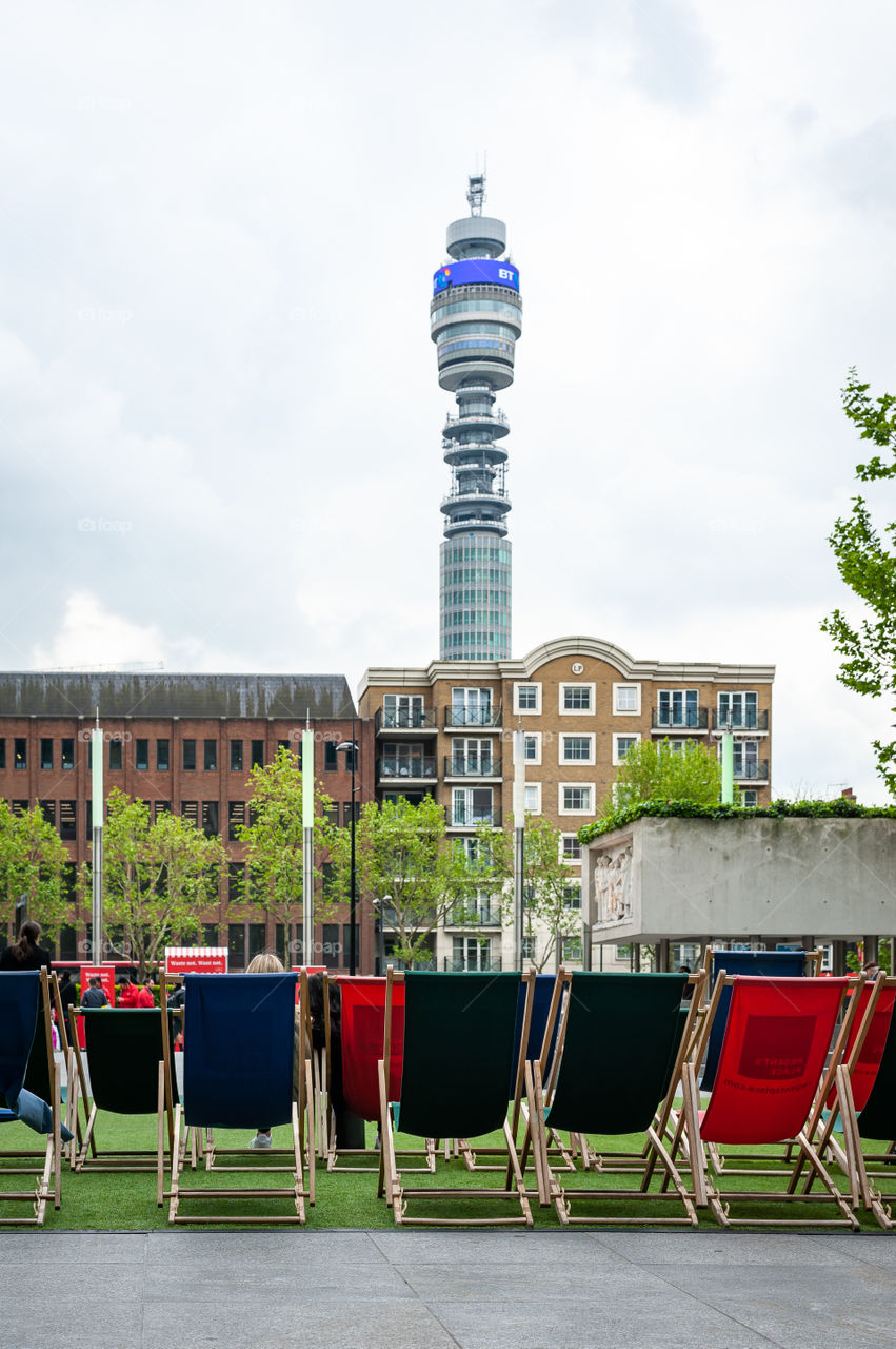 Deckchairs to have a rest in the Regent's Place Square with a view at telecommunication tower. London. UK.