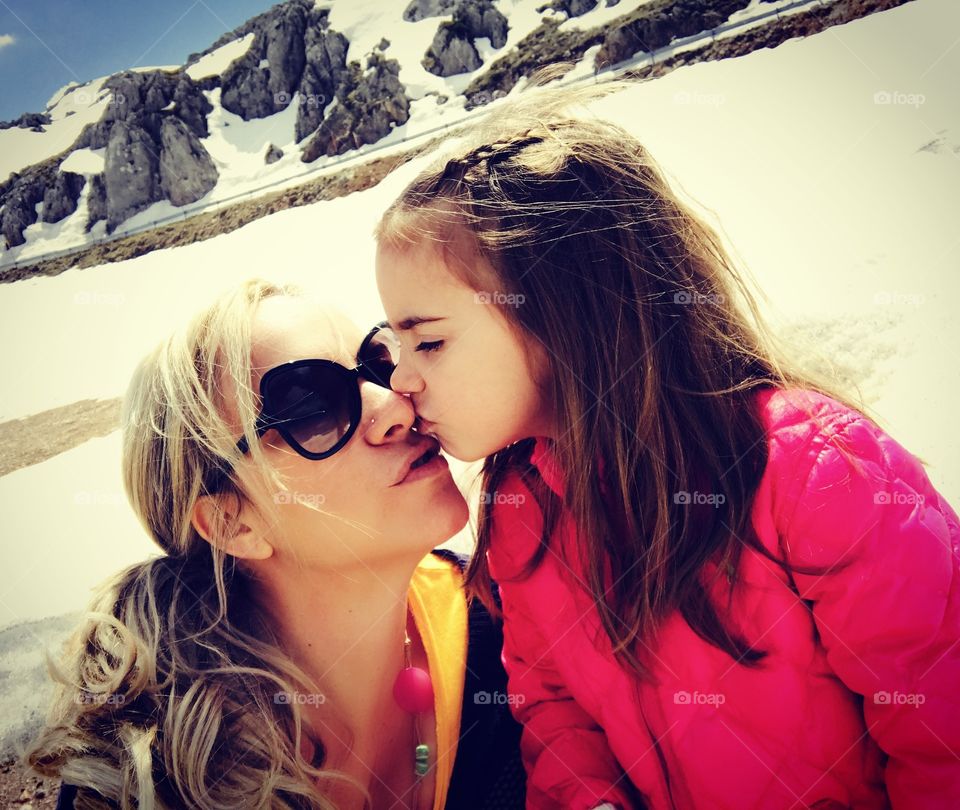 Little girl kissing to her mother