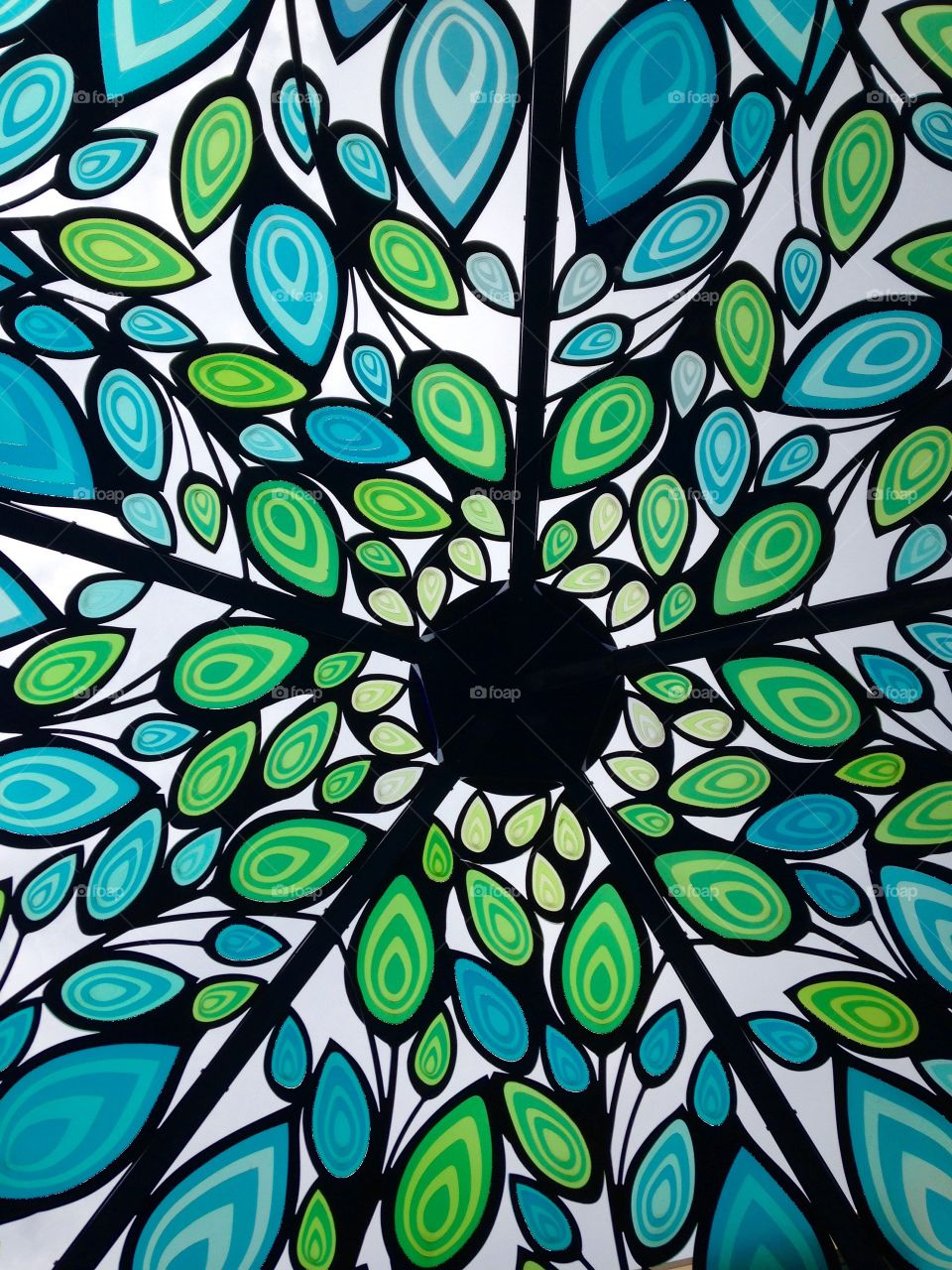 Happy_flower. Looking up under a mosaic of a peacock collage.  