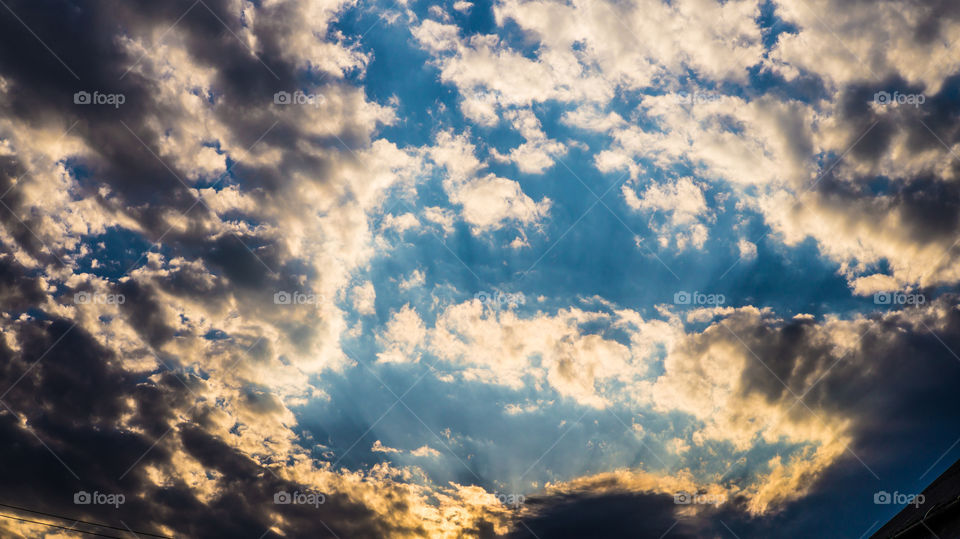 Large clouds float across the sunset sky like sails.
