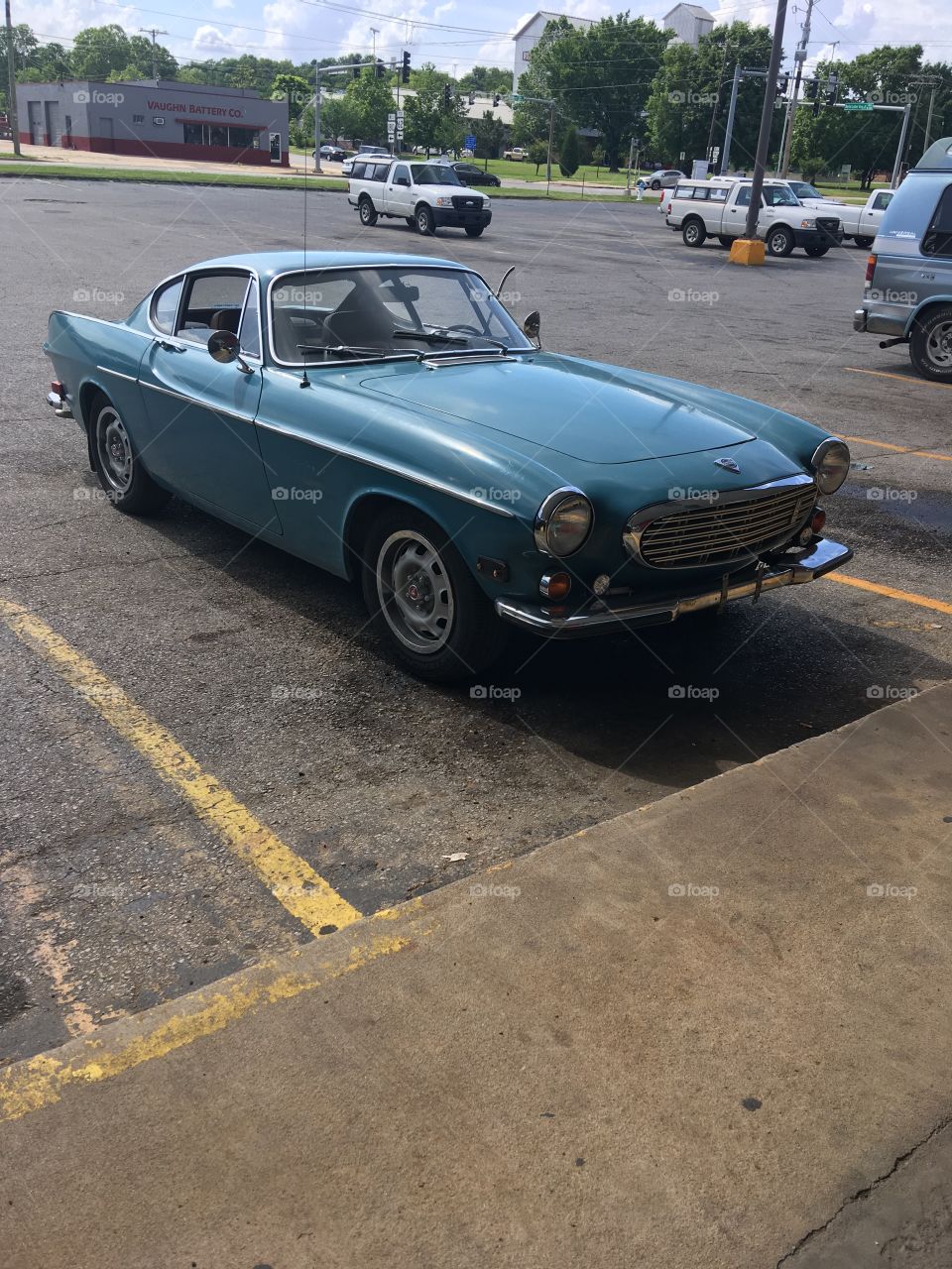 In O Reilly’s parking lot an old Volvo car. Clean looking blue paint sleek and shiny.