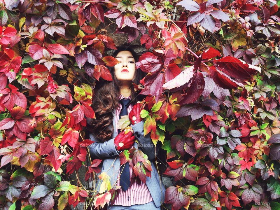 Young woman standing near vine