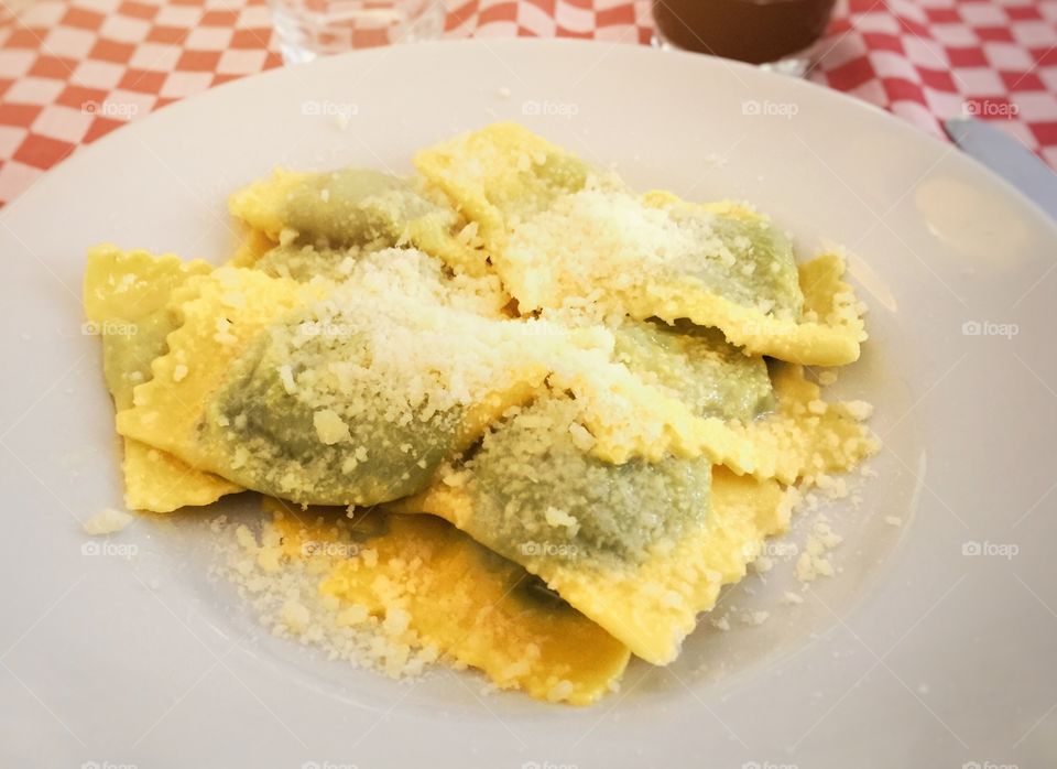 a typical recipe of Italian cuisine: emilian tortelli stuffed with spinach and ricotta and covered with parmesan cheese