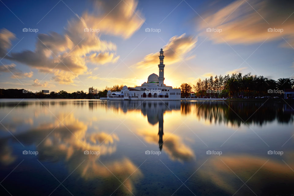 Reflections of mosque during sunset with dramatic sky reflections
