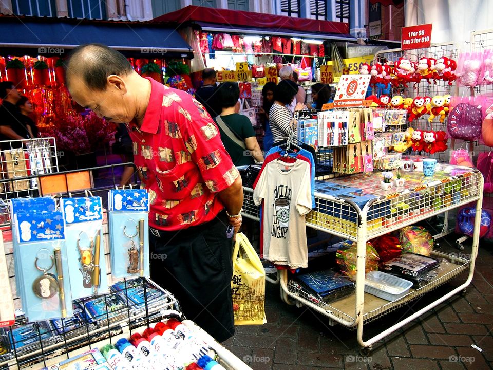 tourists looking at souvenirs sold at chinatown in singapore