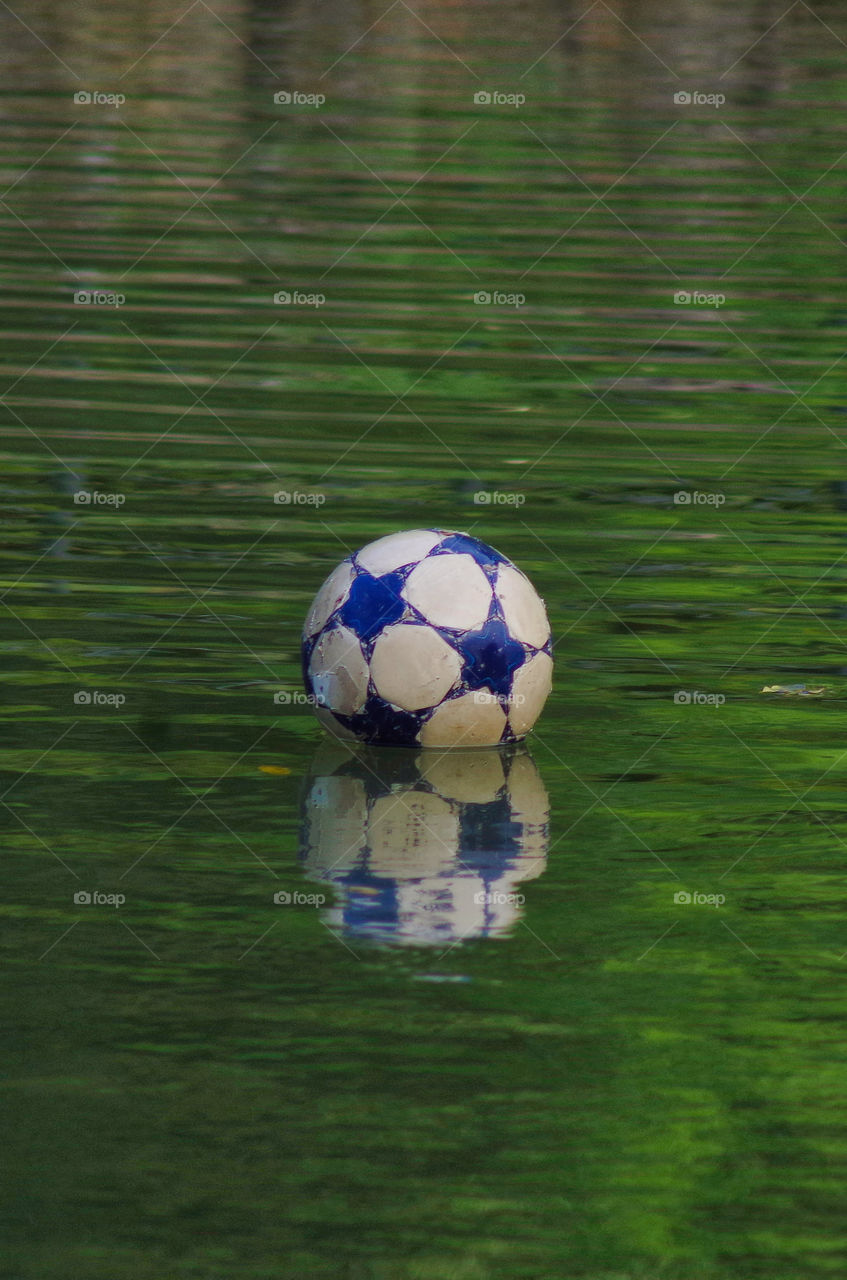 a soccer ball floating in a river water