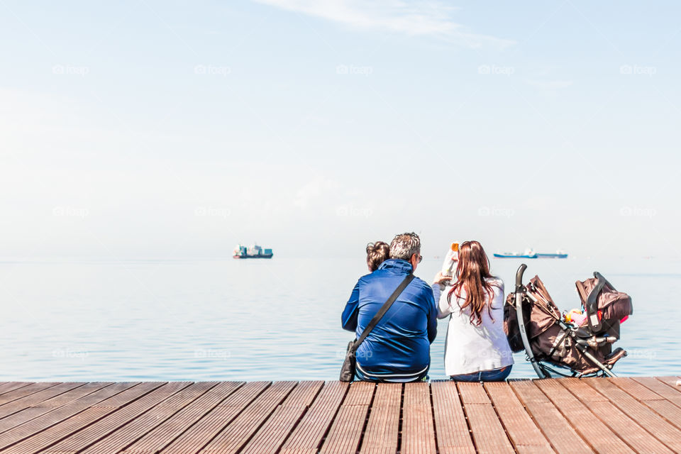 Family Enjoying The View Sitting On The Dock
