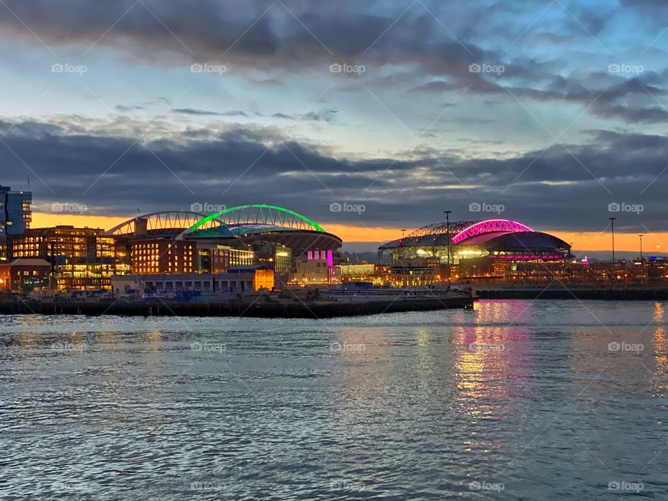 Morning sunrise over the Seattle Waterfront and the Stadium District with CenturyLink Field and T-Mobile Park illuminated 