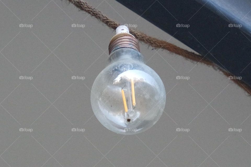 Lightbulb hanging from the roof of an old home