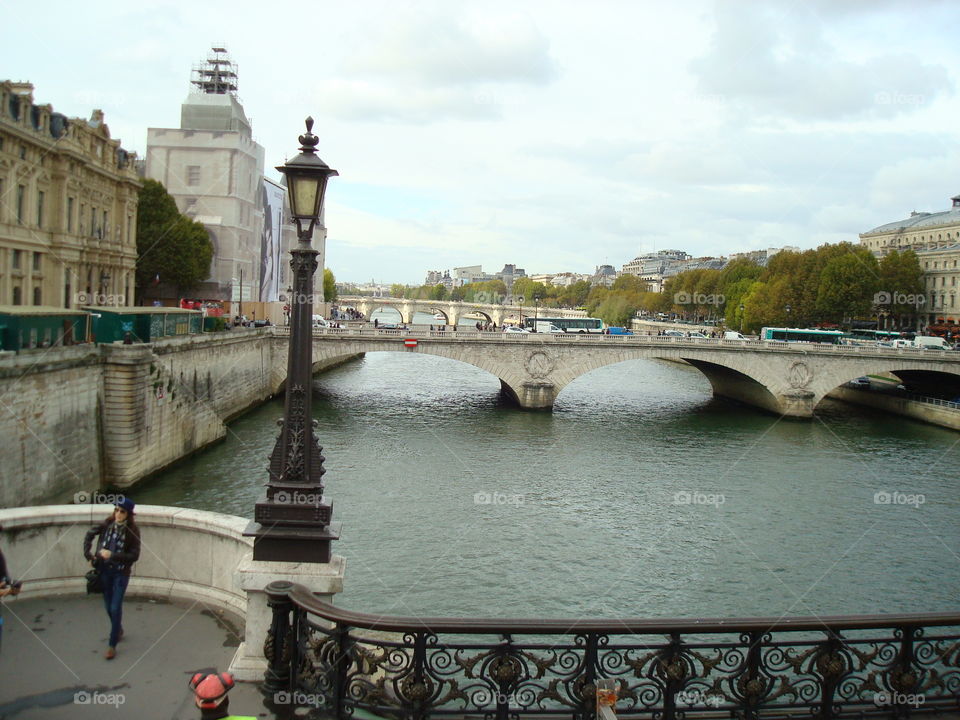 Stone bridges over an urban river in Paris with lamp post