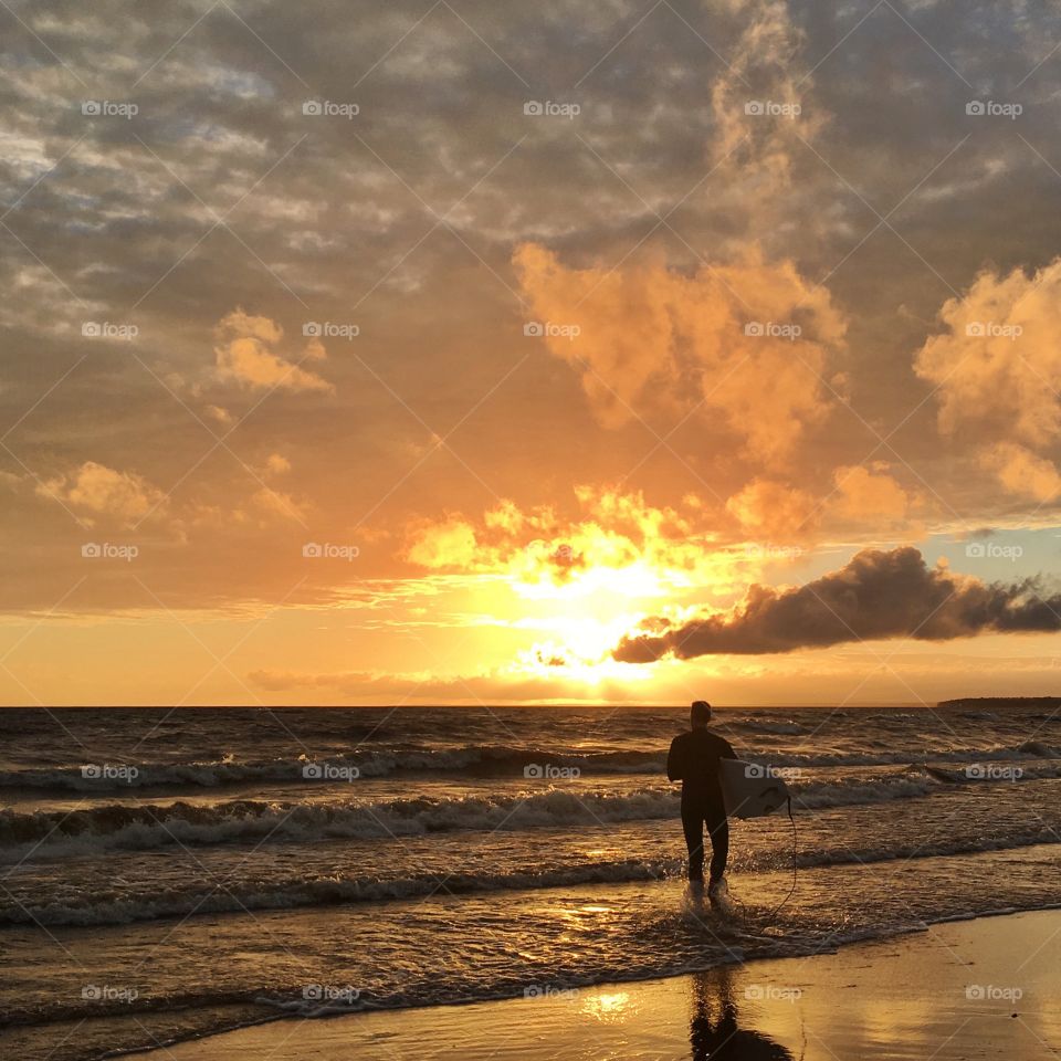 Surfer at sunset on beach