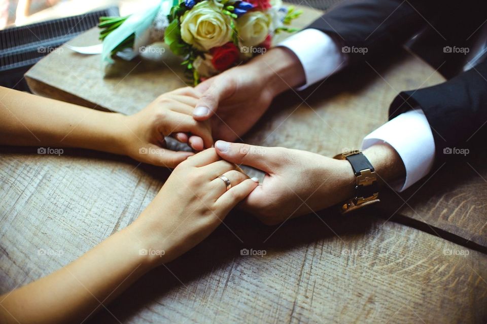 Man holding woman's hand on table
