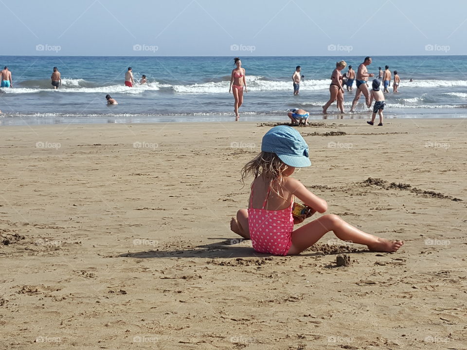 girl on the beach playing in the sand