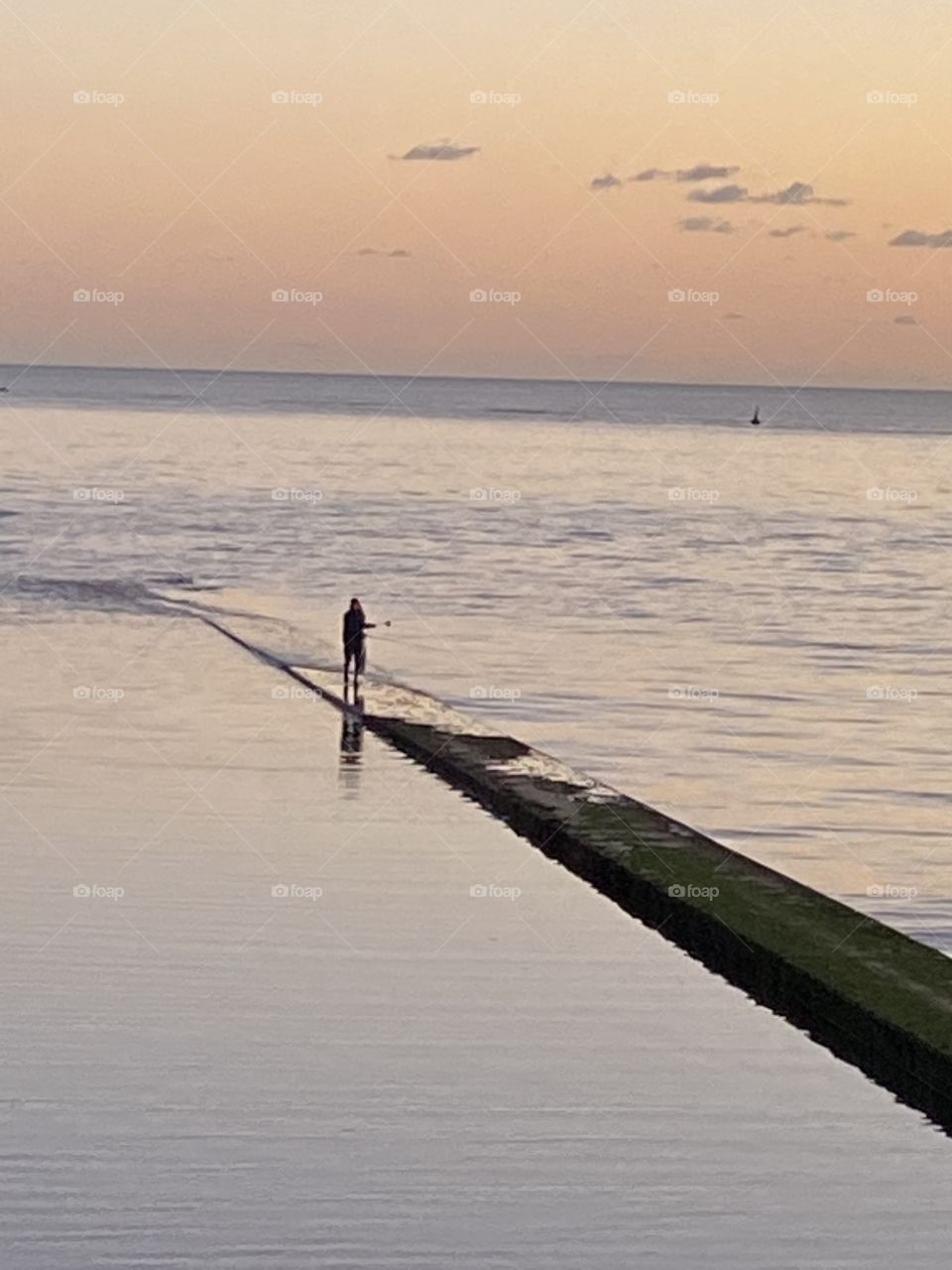 Lone Fisherman, enjoying his fishing and the added attraction of a powerful torchlight, this beautiful sunset.