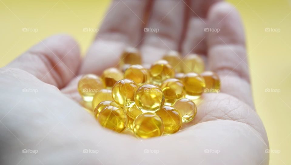 vitamin capsules oils in the hand close up