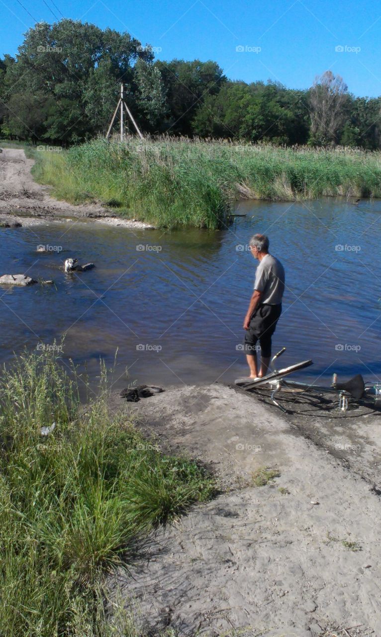 elder man with dog at the river 