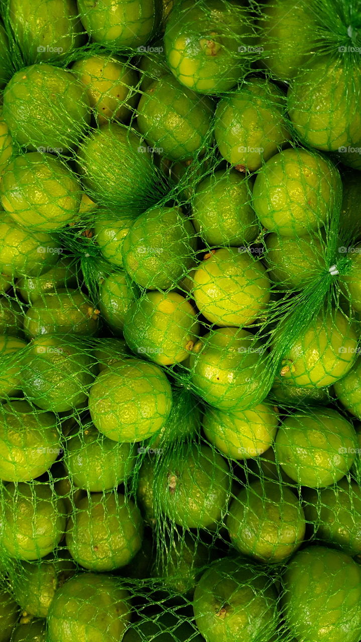 Close-up of limes in green net