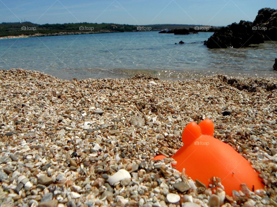 orange color story: orange toys in front of sea