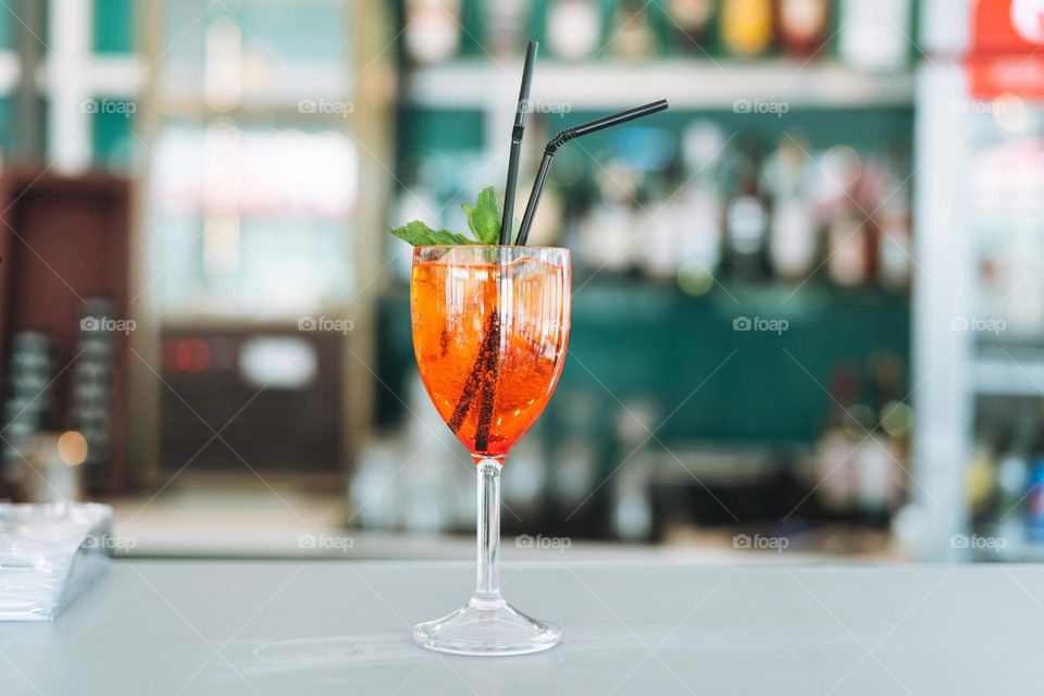 Glass with cocktail with ice on the side of hotel pool bar, summer vacation