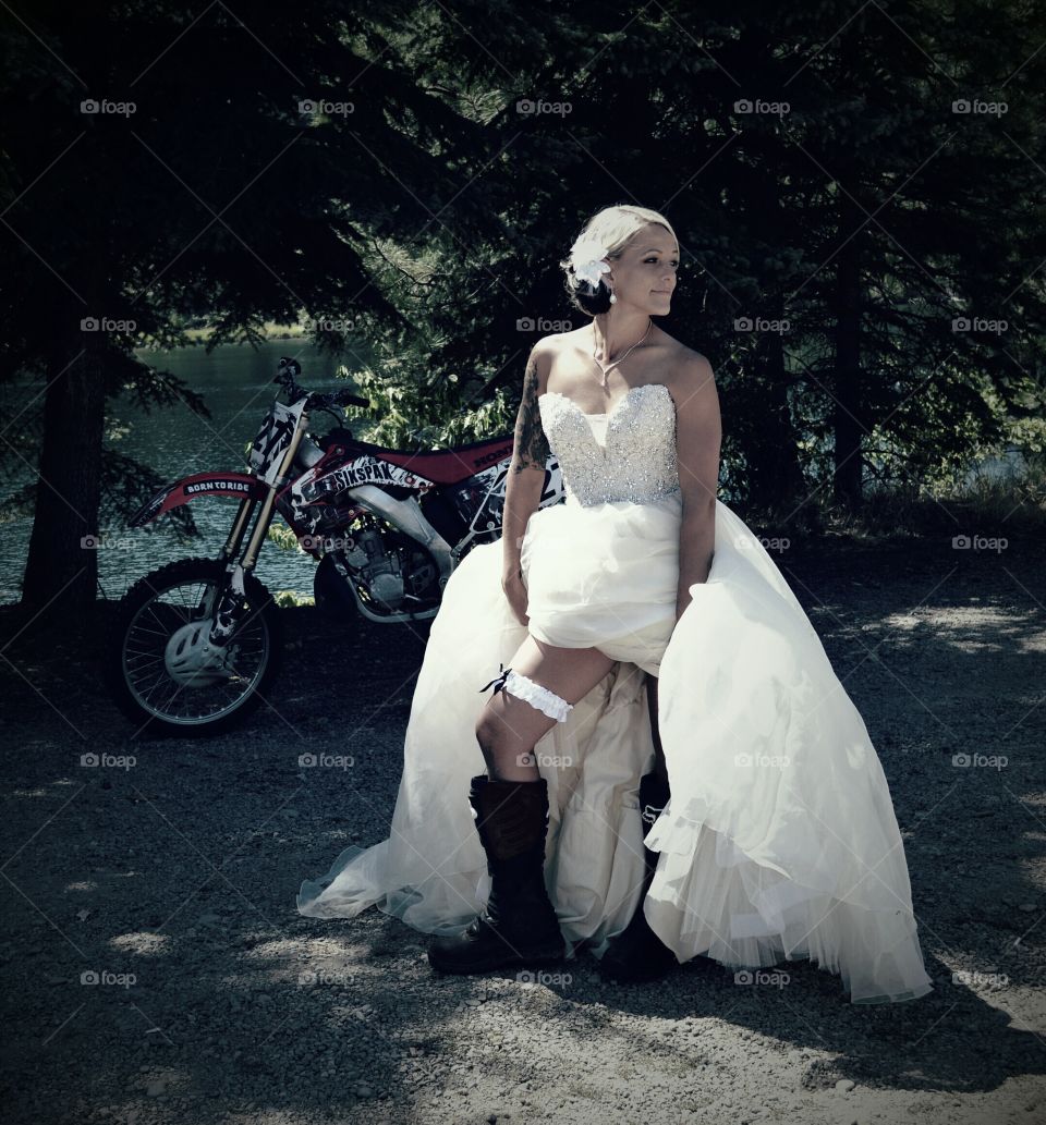 Woman standing near motorbike in traditional gown
