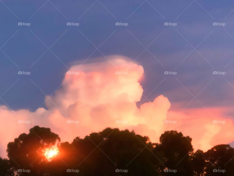 Sunset behind a giant pink cumulous cloud.