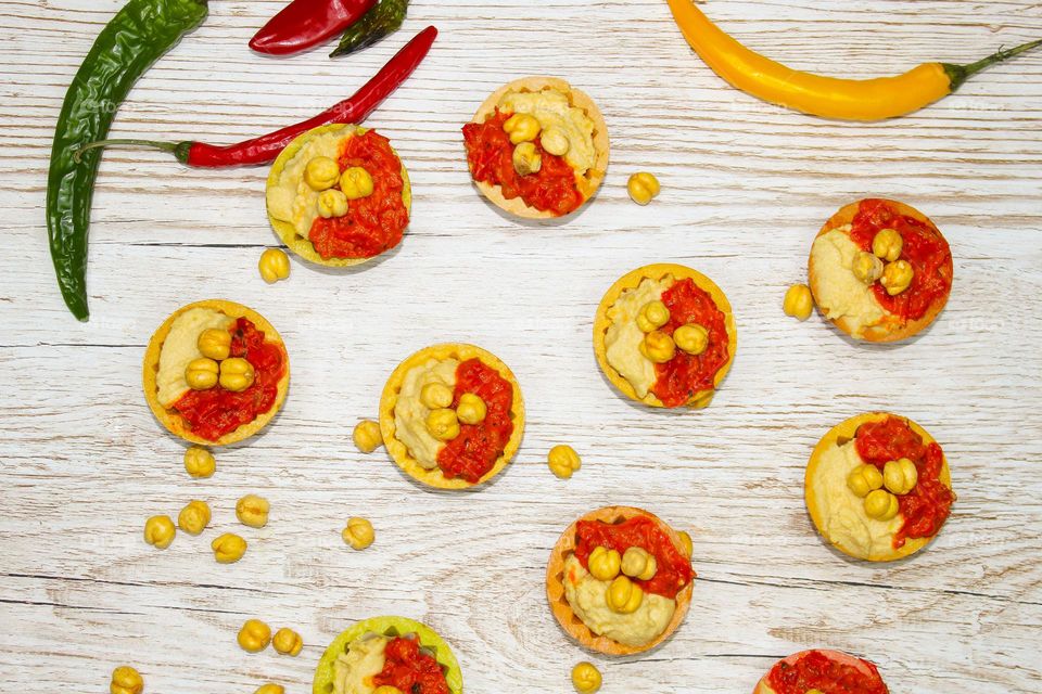 Edible basket filled with humus and pepper sauce (ajvar) on a table.  Top view of food