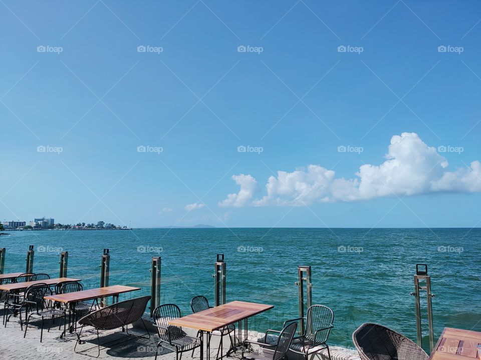 Tables and chairs for dining in the seaside and sky atmosphere.