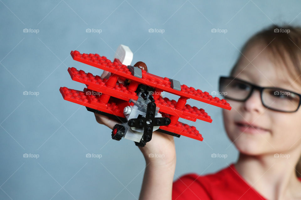 Child playing with Lego airplane