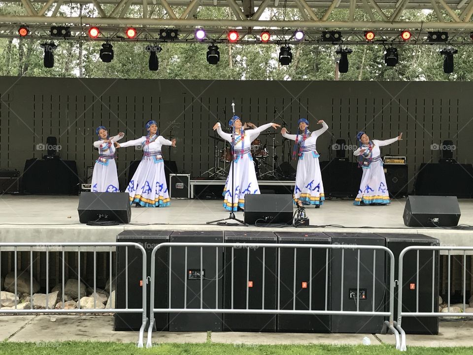 Women in colourful dresses perform at Bower Ponds for Canada Day.