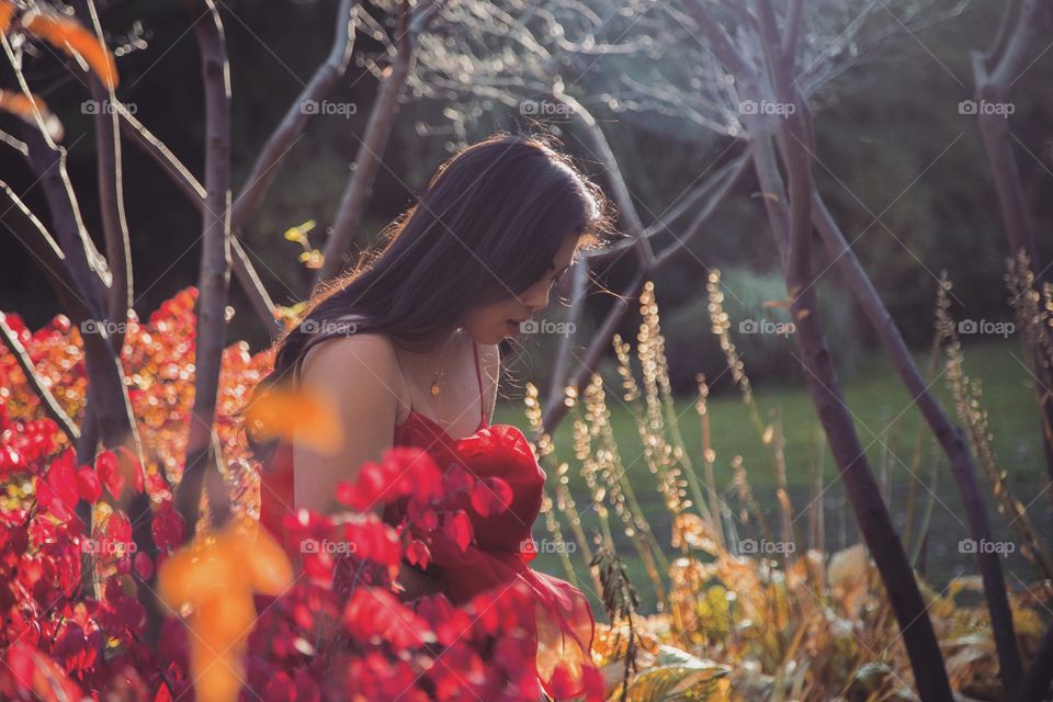 Young girl in bright red walking through a garden