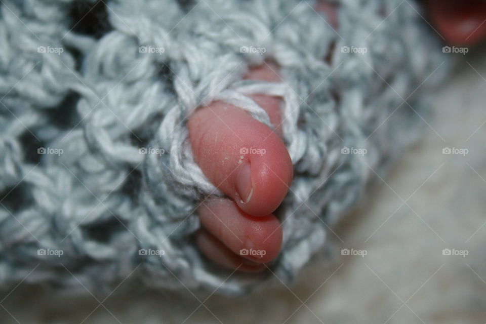 Tiny Toes. Newborn's toes peek through a crochet blanket. 