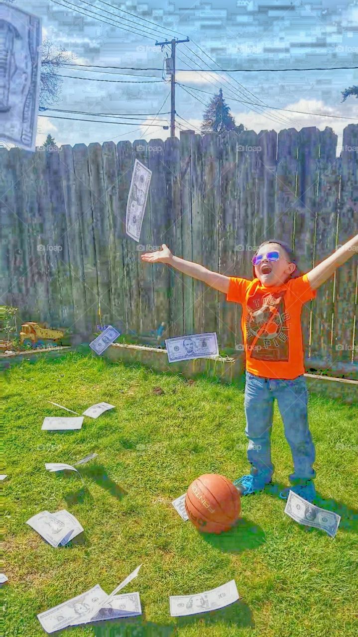 Cartoon style abstract of boy in shades and orange shirt, looking upwards with excitement as he throws oversized money into the air.