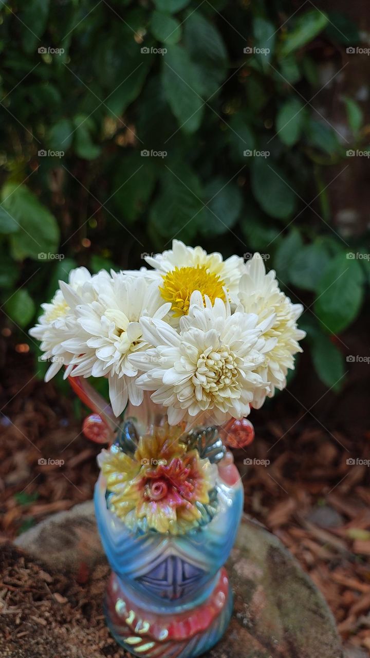 Beautiful white flowers in a colourful flowerpot with a flower sculpture, Flowers in a vase, colourful vase, white flowers in a vase