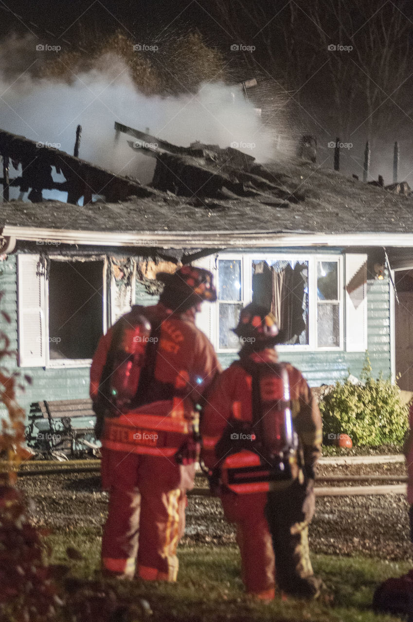 Fire fighters discuss the house fire