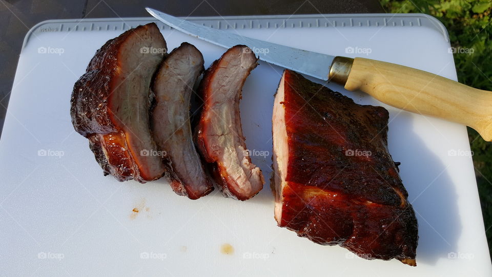 Barbecue ribs on cutting board with knife