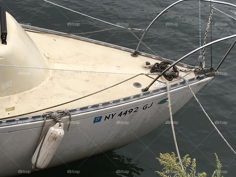 Back end of the „Salvation“ sailboat in the waters of the East River at Newtown Creek in Long Island City, Queens, New York photographed from the shore at low tide on a late Fall afternoon in 2018. Hypnotic Productions