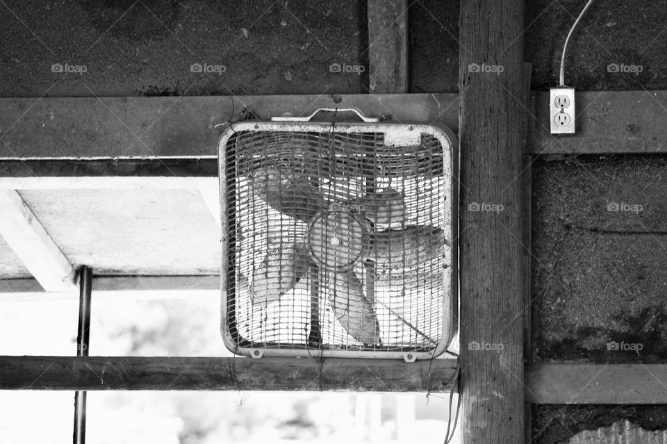 A box fan in an open wooden structure 