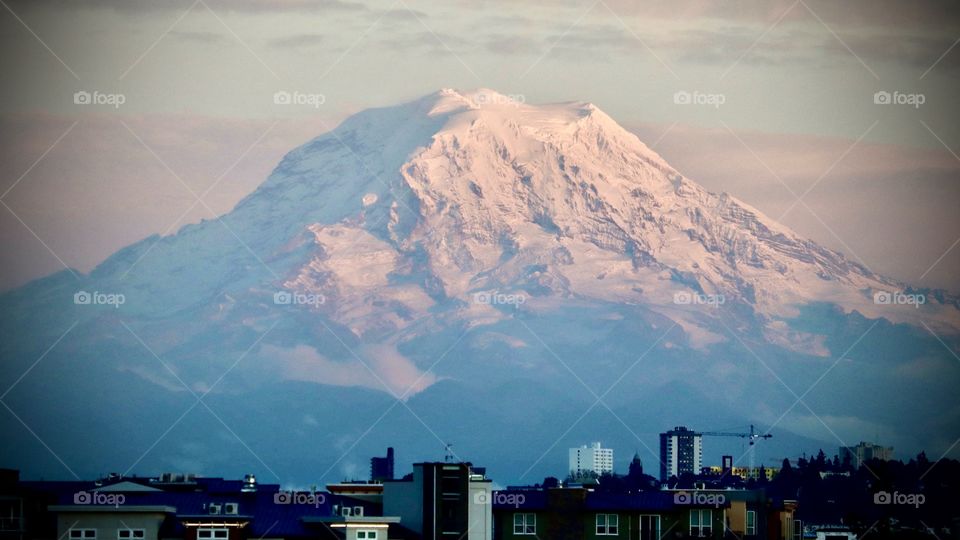 Mount Rainier, also known as Tahoma, stands tall along the Cascade Mountain Range. Tacoma, Washington is in the foreground 