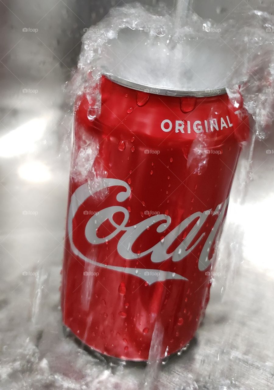 Coca-Cola can getting rinsed off