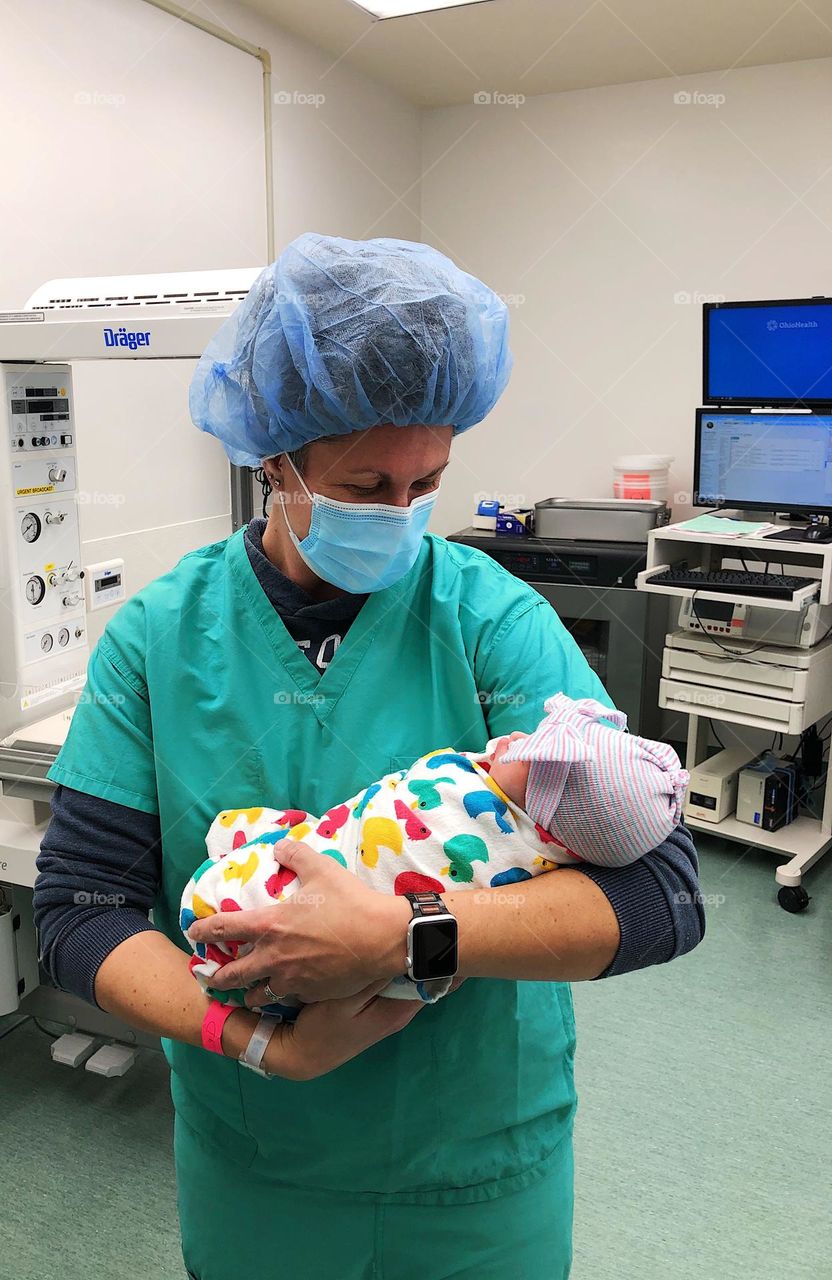 Mother holds baby for the first time, happiness as an emotion in our lives, holding newborn baby for the first time, mother loving baby, mother is happy to hold baby for the first time, newborn baby is loved, happiness in mothers eyes 