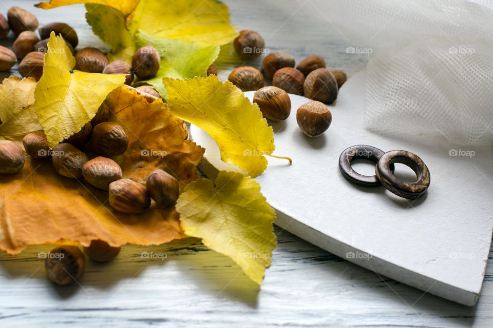 rustic, autumn wedding invitation background, leaves, nuts and wooden wedding rings