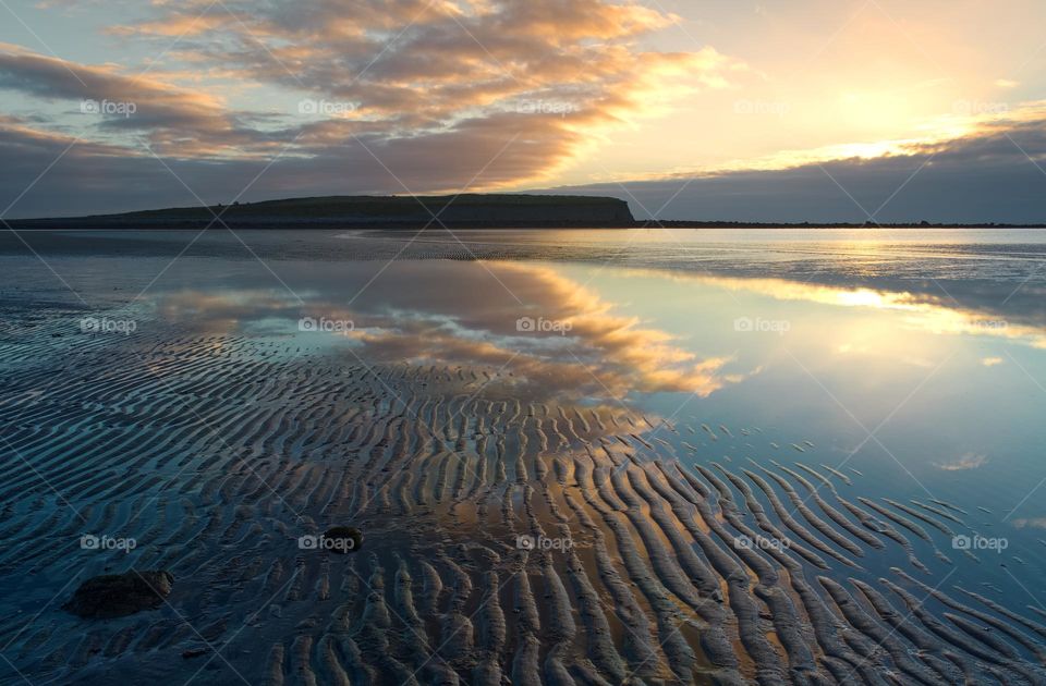 Clouds reflected in water at Silverstrand beach in Galway, Ireland