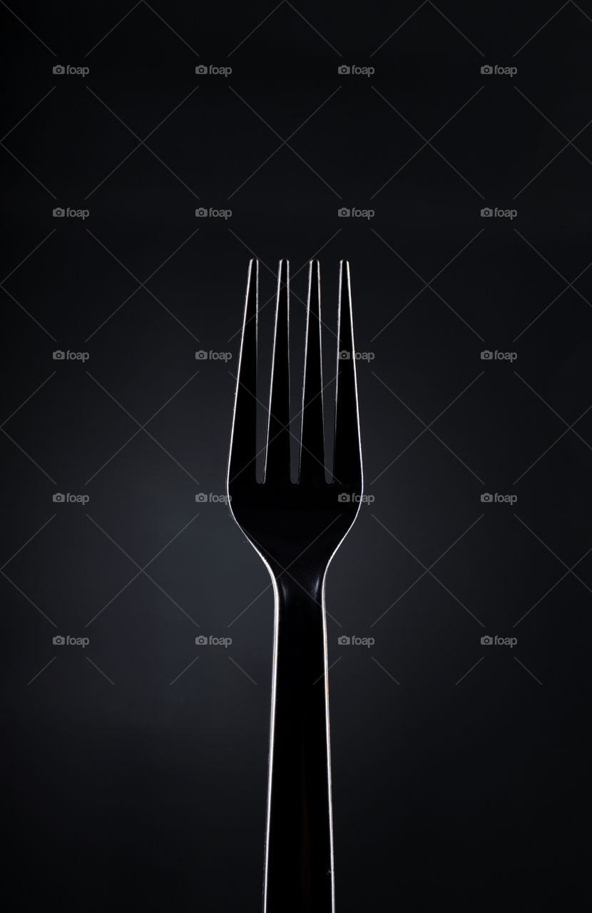 Black plastic fork on dark background
