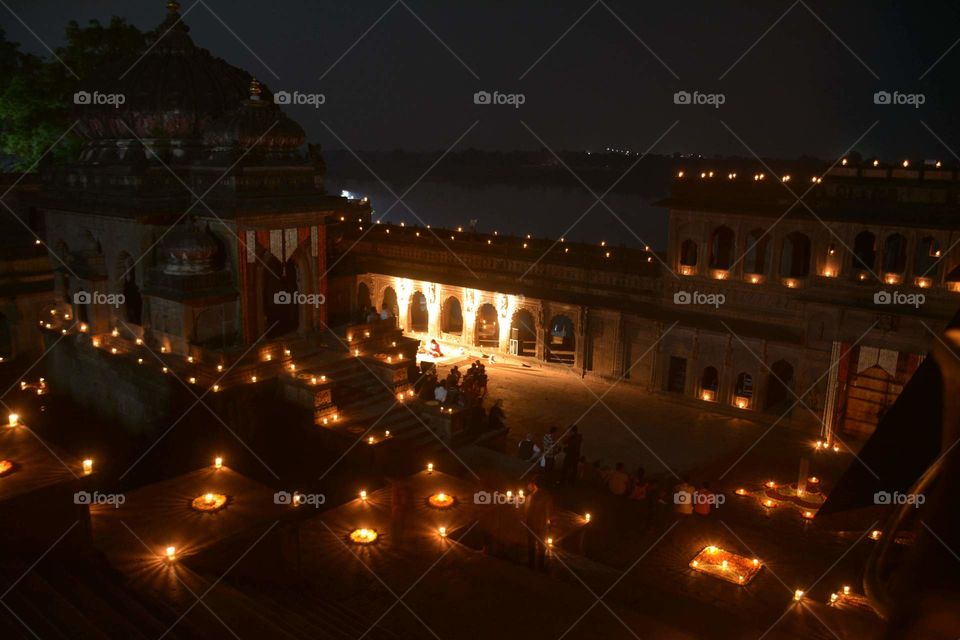 Fort and building decorated with candlelight and surrounded by water