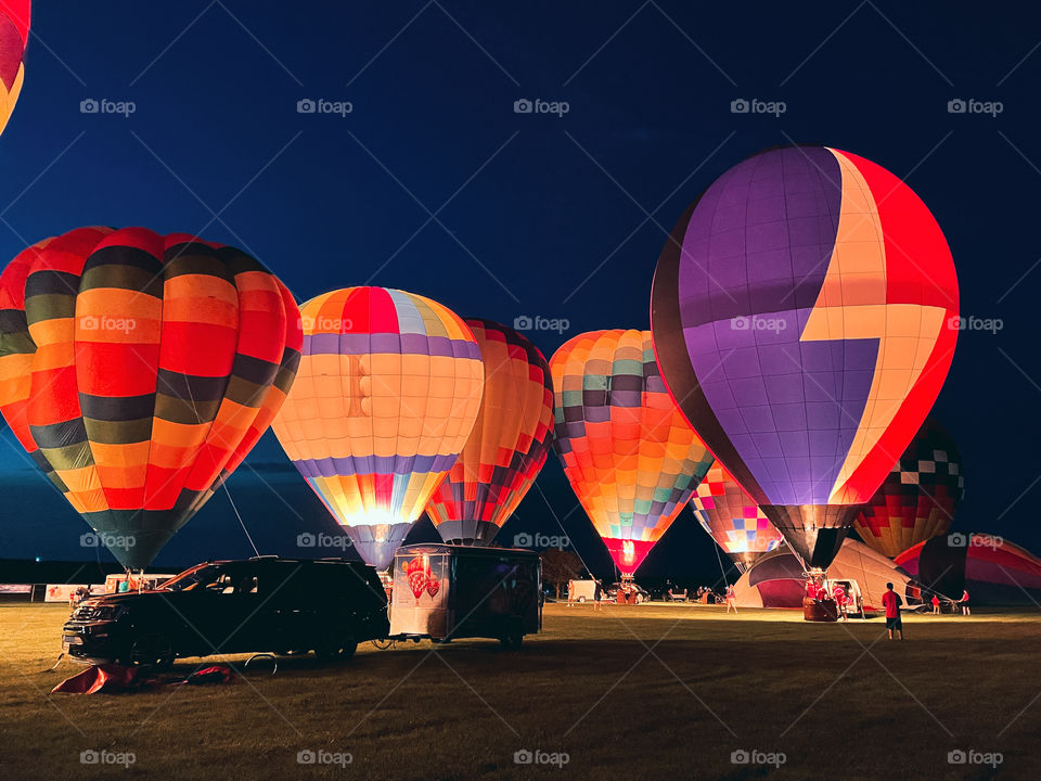 Colorful glowing hot air balloon glow light up the night sky, spectacular display, ballooning fiesta