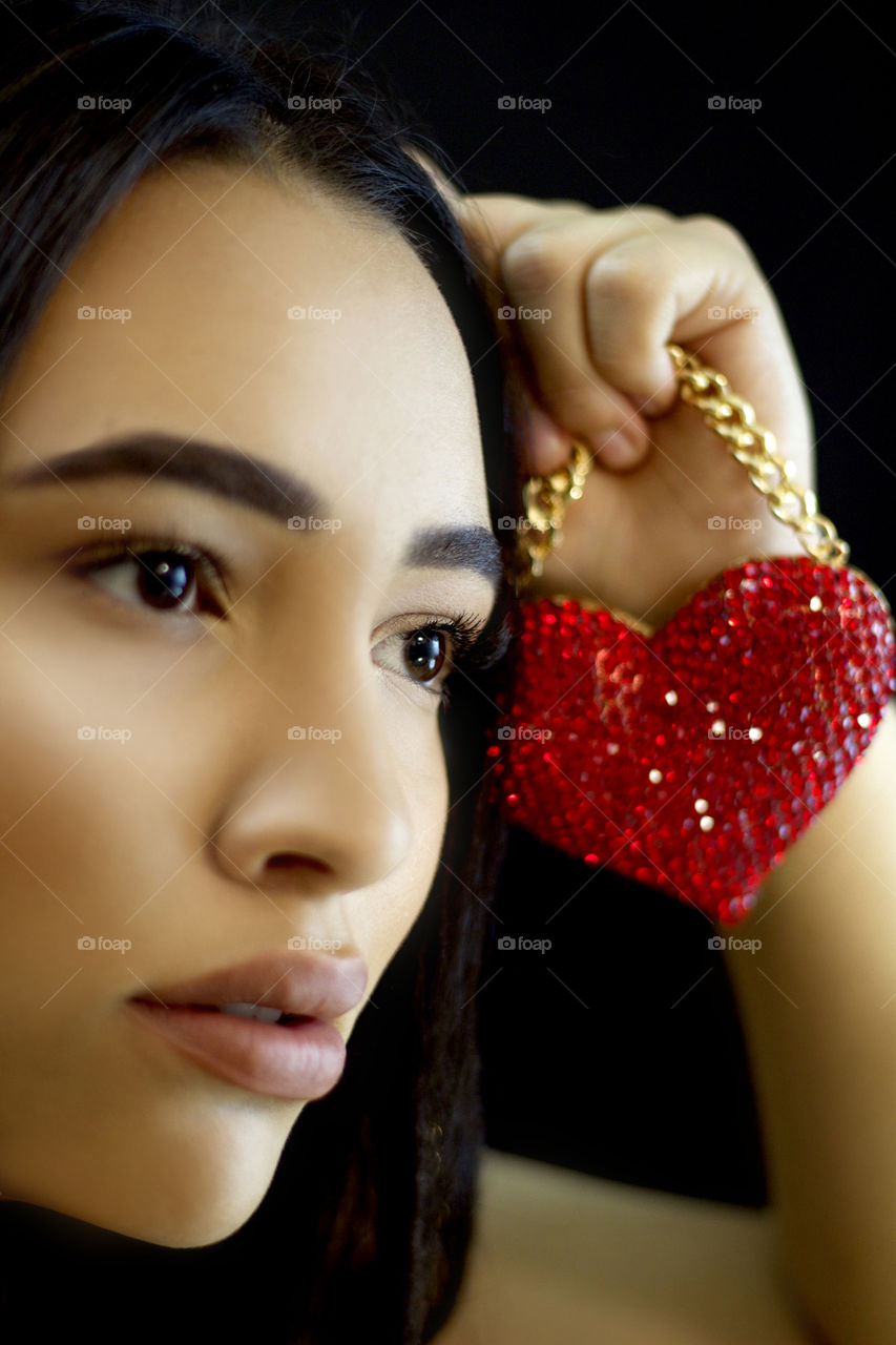 Close-up of Asian holding small glitter heart