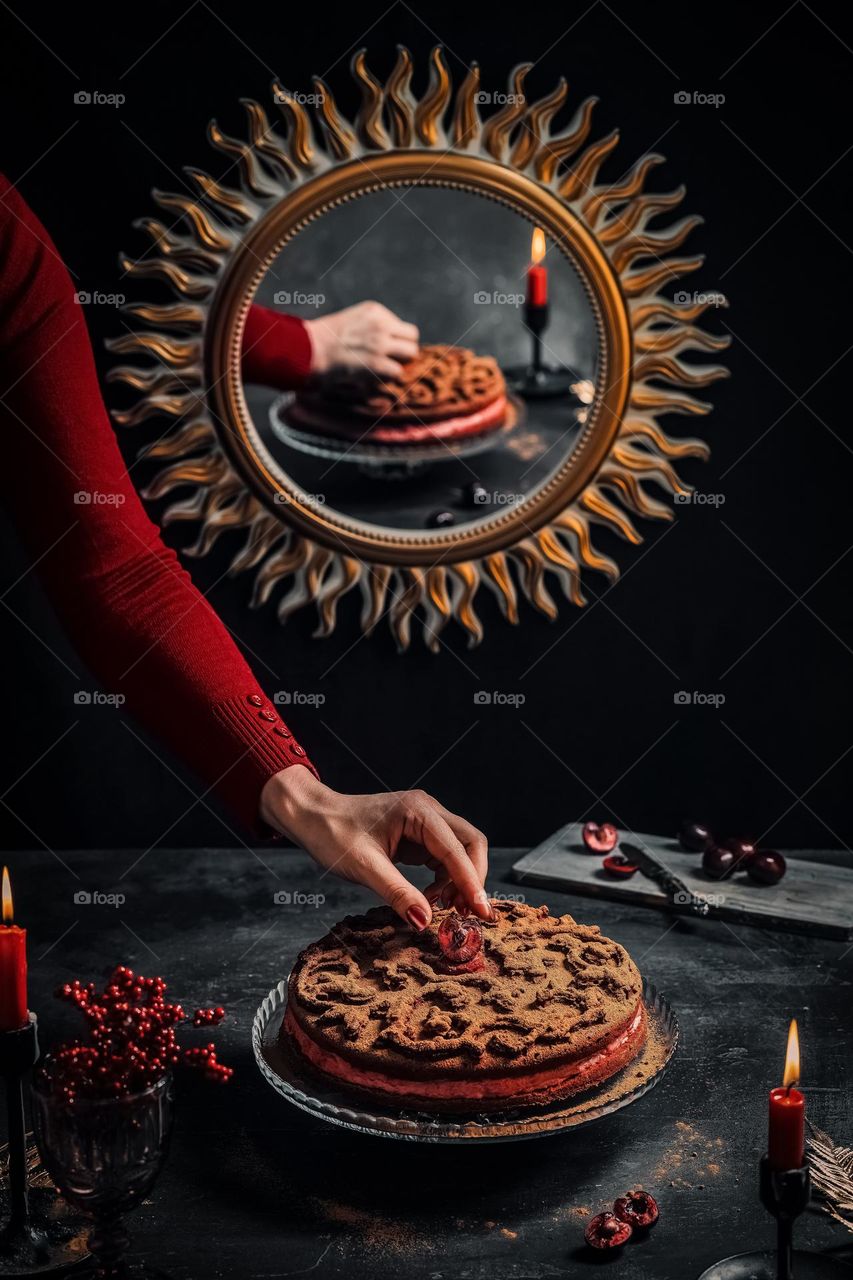 stylized juicy and dark composition - stylization of food. Cooking culinary works, baking and presentation of cakes. Confectionery business. Sweet background. Cake with cherry filling