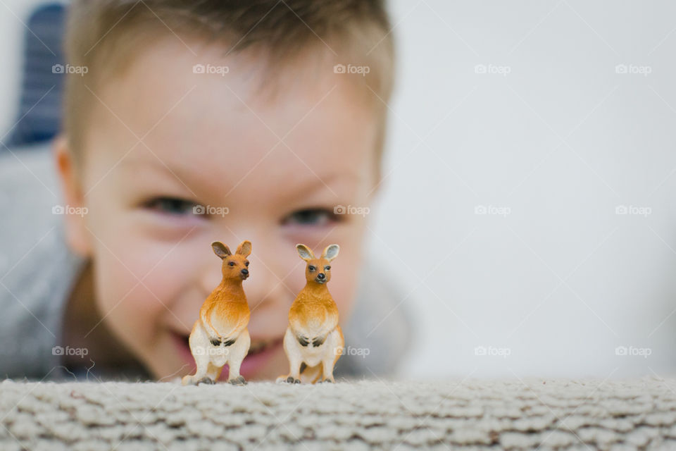 5 year old boy playing with plastic animals 