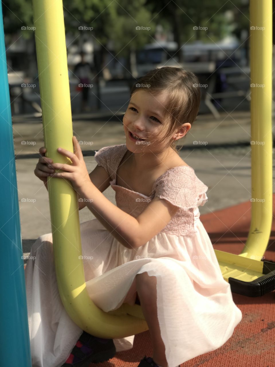 Smiling girl sitting on metal in park