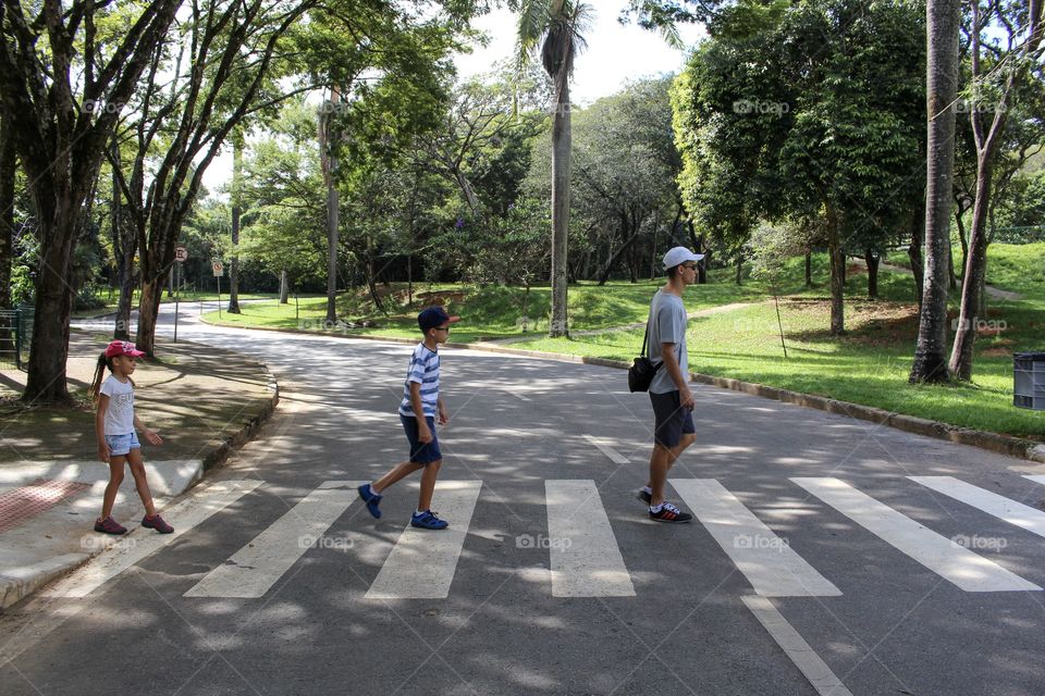 Father walking with kids like Abbey Road Beatles